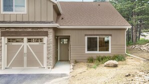 A two-story house with a garage, a front door, and a window.