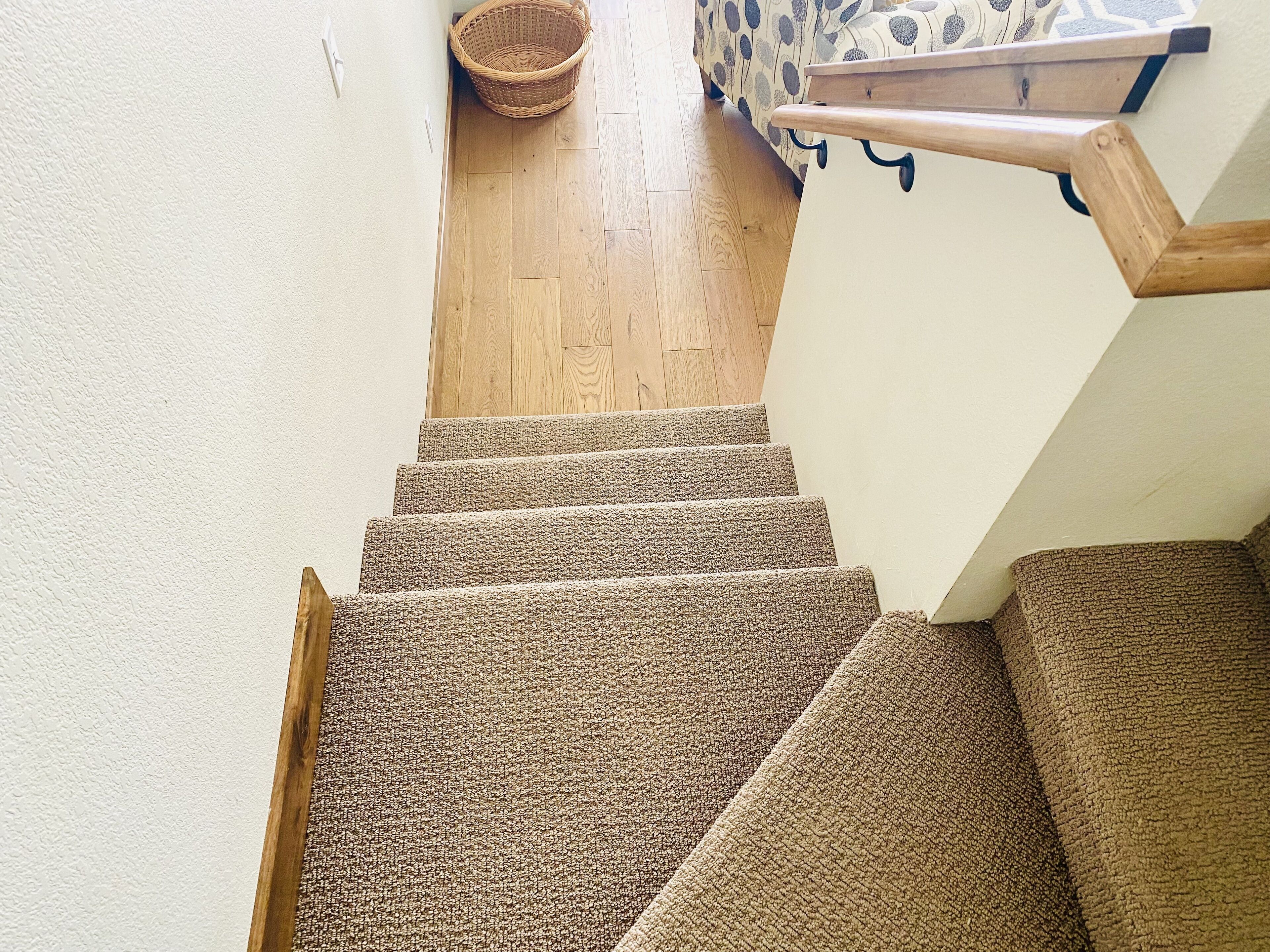 A staircase with carpeted steps and wooden handrails.