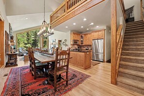 A spacious kitchen with wooden cabinets, a central island, and a stainless steel refrigerator. - Fall River Retreat #11- 3 BDR Condo on River in Estes Park CO - EV# 6196 (Estes Park)