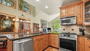 Una cocina moderna con gabinetes de madera, electrodomésticos de acero inoxidable y una isla grande.