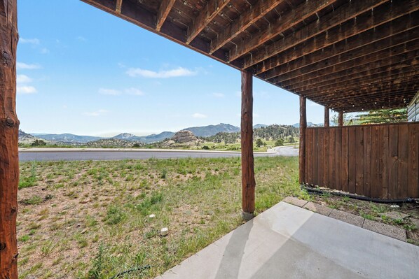 A covered outdoor area with a view of a road and mountains.