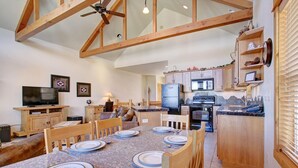 A spacious kitchen with wooden cabinets, a dining table set for four, and a ceiling fan.