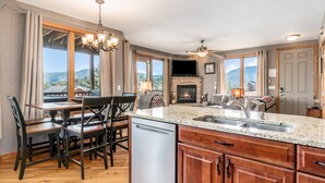 Une cuisine spacieuse dotée d’un plan de travail en granit, de meubles en bois et d’un lave-vaisselle encastré.