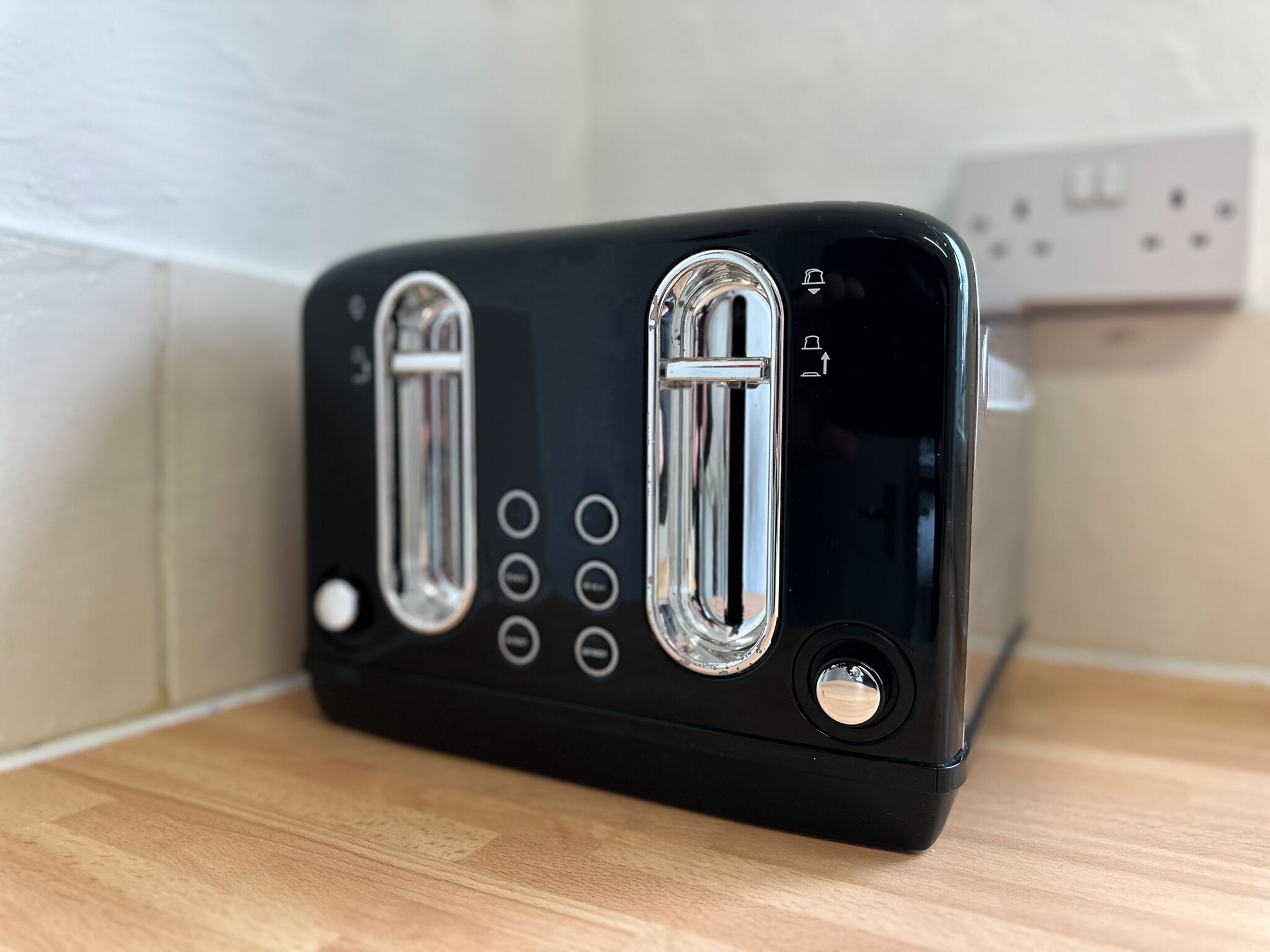 A black toaster with two slots, a power button, and a dial with settings.