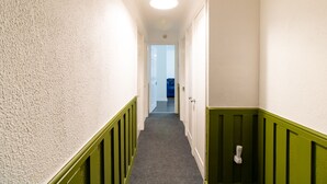 A narrow hallway with white walls, green trim, and a carpeted floor. - Stunning 2-bed Apartment in Washington (Washington)