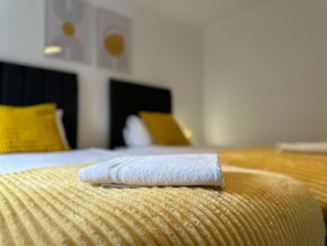 A bed with a yellow textured bedspread and a white towel on it. - Stunning 2-bed Apartment in Washington (Washington)