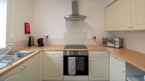 A kitchen with a stainless steel range hood, a built-in oven, a toaster, and a sink. - Stunning 2-bed Apartment in Washington (Washington)
