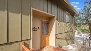 Une maison avec une porte en bois et un paillasson devant l’entrée.