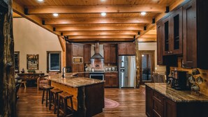 A spacious kitchen with wooden beams, a central island, and modern appliances.