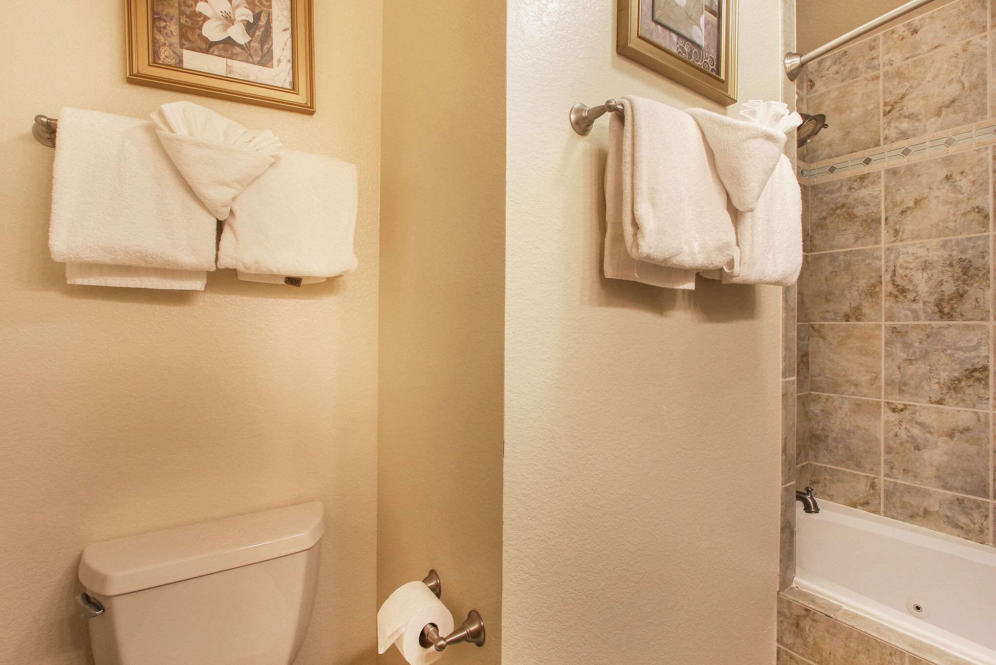 A bathroom with two towel racks, a toilet, and a shower area.