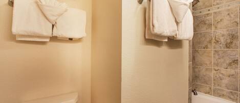 A bathroom with two towel racks, a toilet, and a shower area.