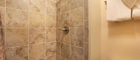 A bathroom with a shower, tiled walls, and a toilet.