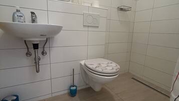 A bathroom with a sink, toilet, and shower.