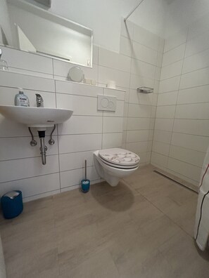 Ein Badezimmer mit Waschbecken, Toilette und Dusche.
