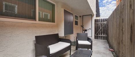 A patio area with a sofa, chairs, and a table.