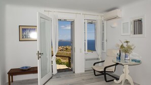 A room with a view of the sea, a dining table with a vase, and a bench. - Charming 5-bed Villa in Mykonos (Mykonos)
