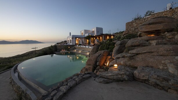 A resort with a infinity pool, stone walls, and a view of the sea. - Charming 5-bed Villa in Mykonos (Mykonos)
