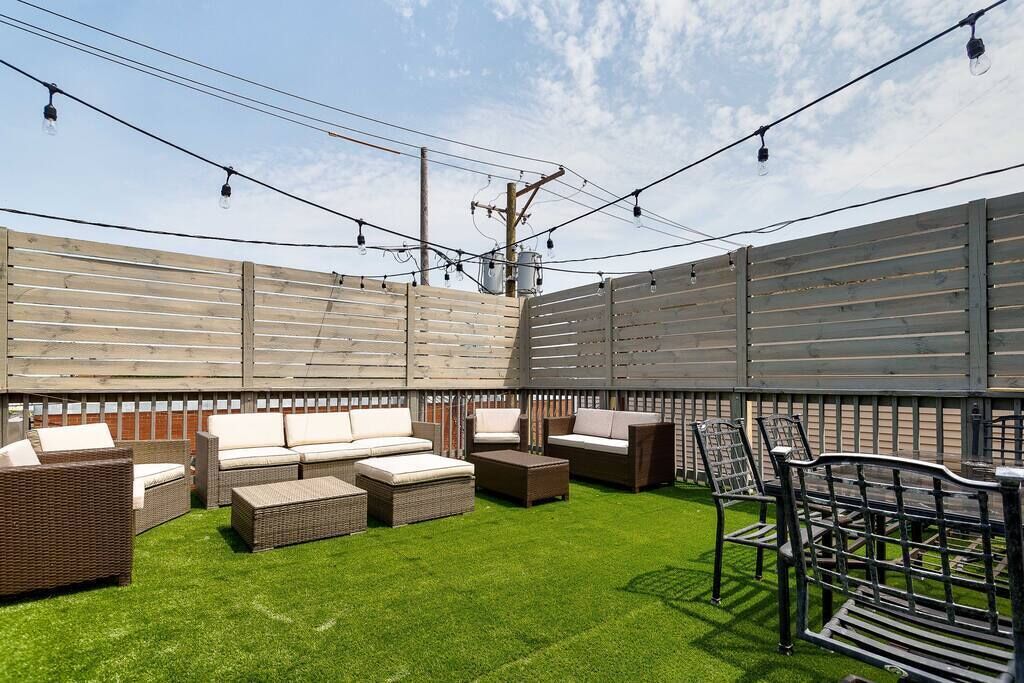 An outdoor patio area with wicker furniture, a table, and chairs.