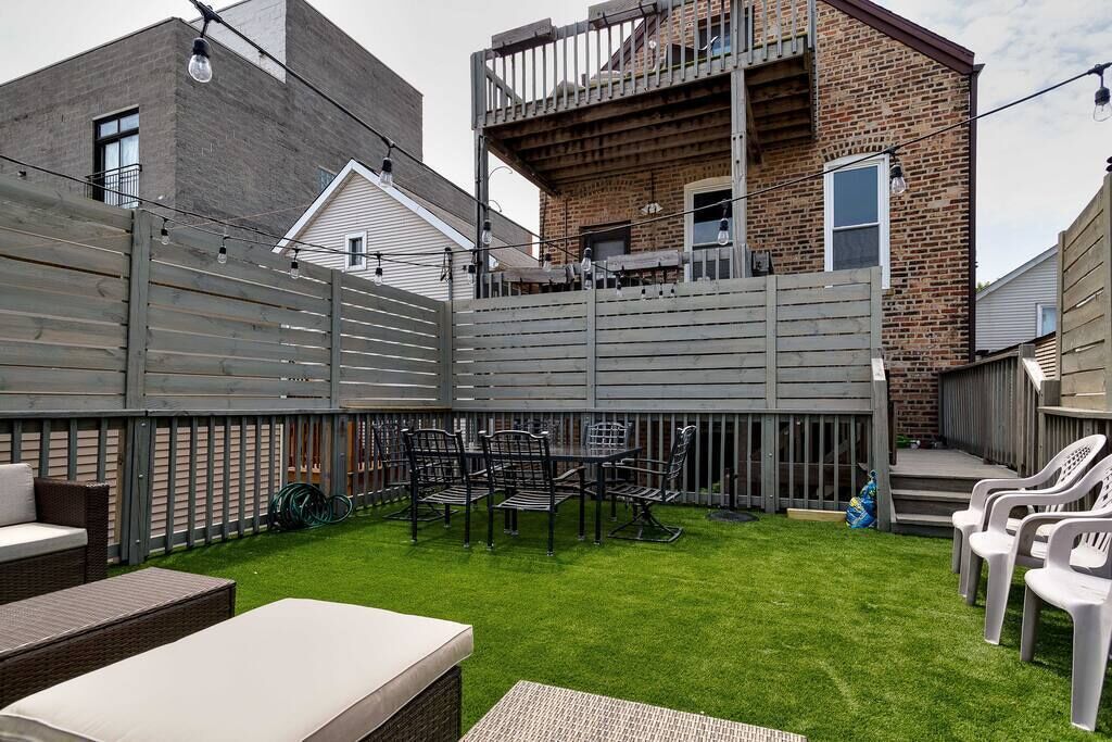 Un jardin avec un espace patio, une petite table et des chaises.