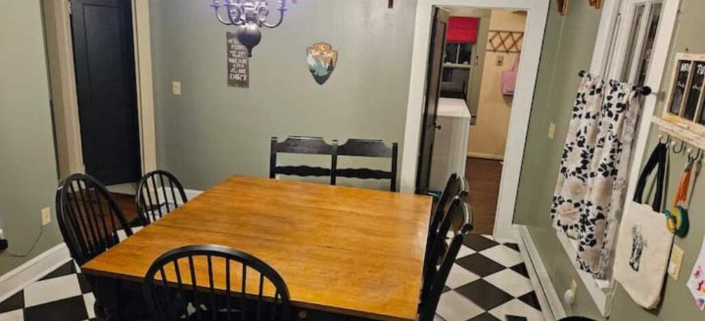 A dining area with a wooden table and four chairs.