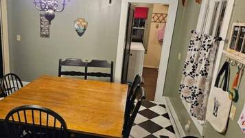 A dining area with a wooden table and four chairs.