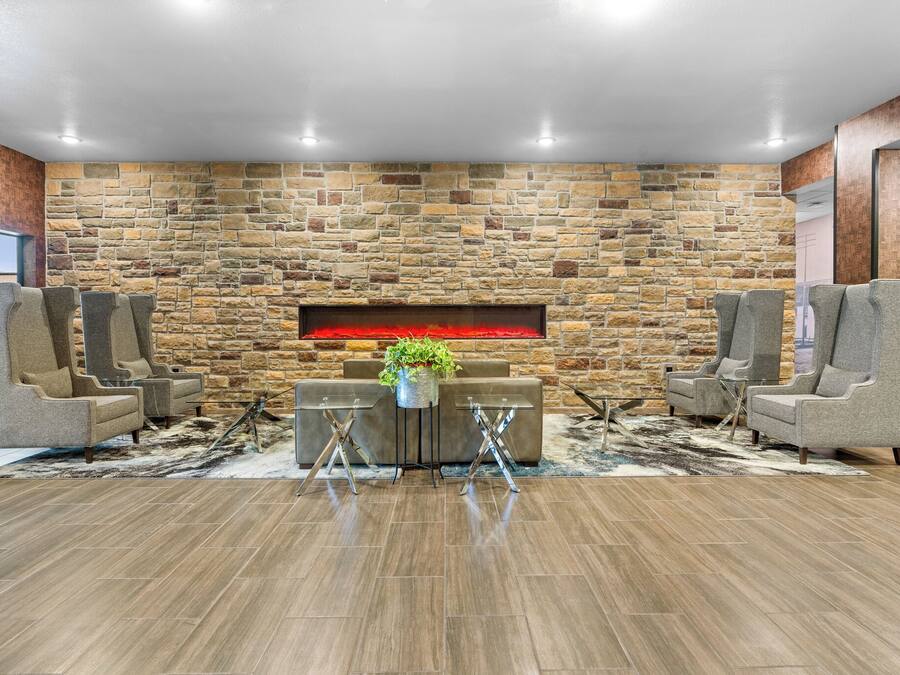 A modern lounge area with a stone wall, two sofas, a coffee table, and a fireplace.