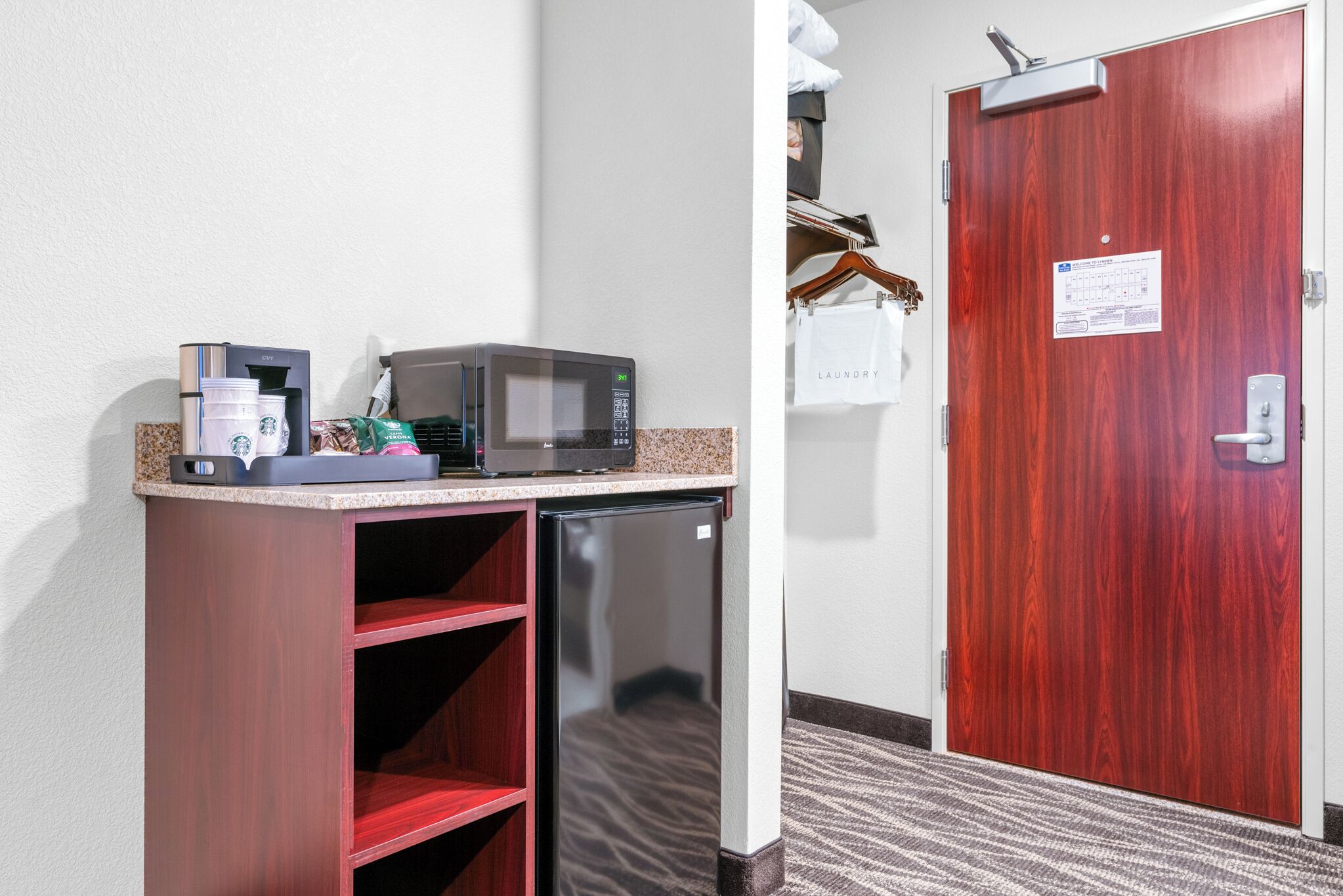 A kitchenette with a coffee maker, microwave, and refrigerator.