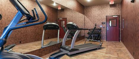 A gym with exercise equipment including treadmills and an elliptical machine.