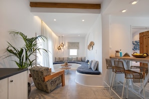Relax in this open-plan living space with a curved seating area and kitchen nook.