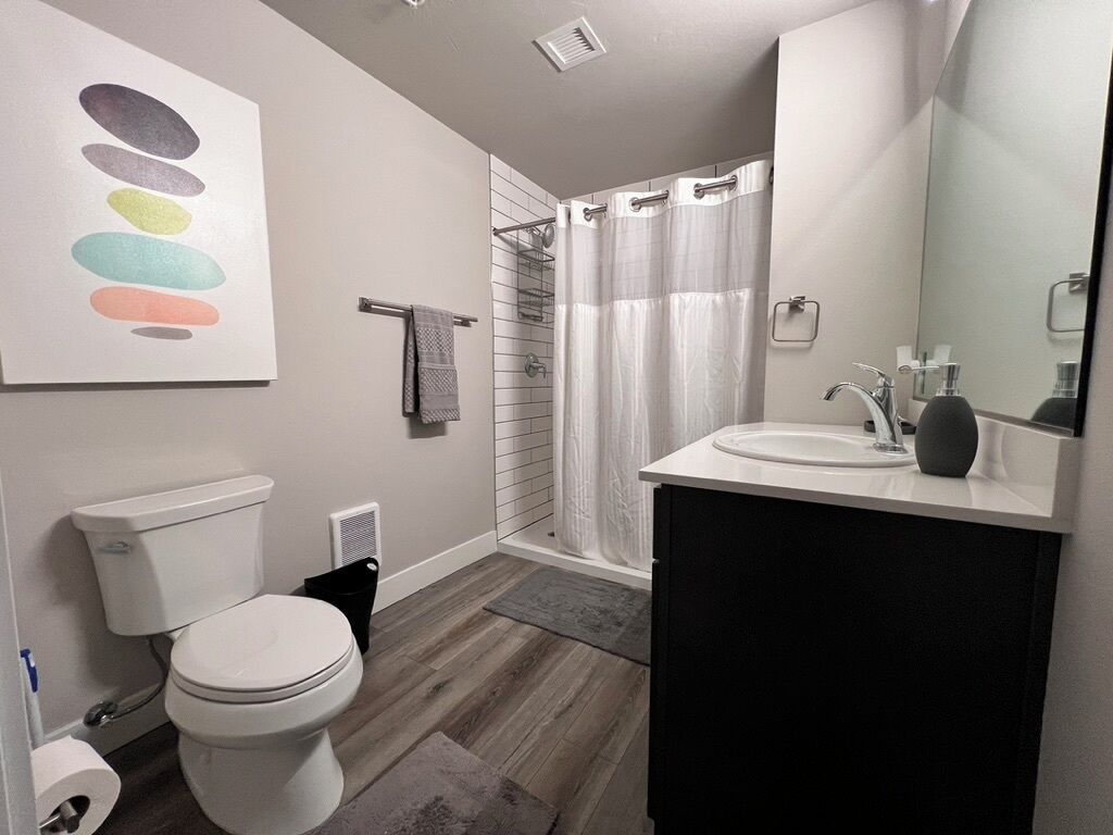 Une salle de bain moderne équipée de toilettes, d’une douche et d’un lavabo.