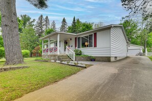 A single-story house with a porch, a garage, and a well-maintained lawn. - Boyne City Retreat Near Beaches & Mtn Resort! (Boyne City)