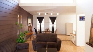 A modern living room with a sofa, a coffee table, and a dining area with a table and chairs. - Sunset Included in your stay !!! (Tijuana)