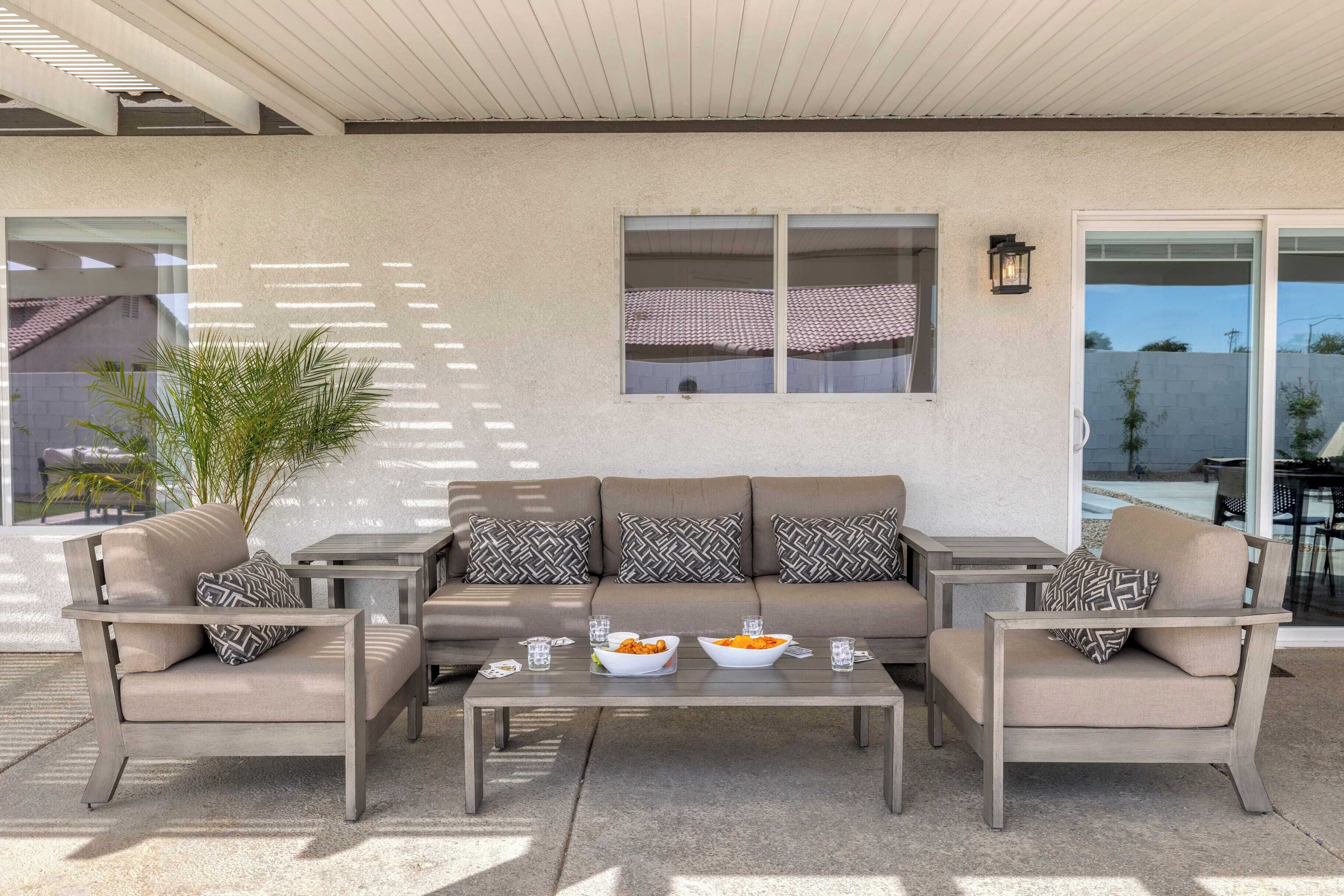 An outdoor seating area with a sofa, two armchairs, and a coffee table.