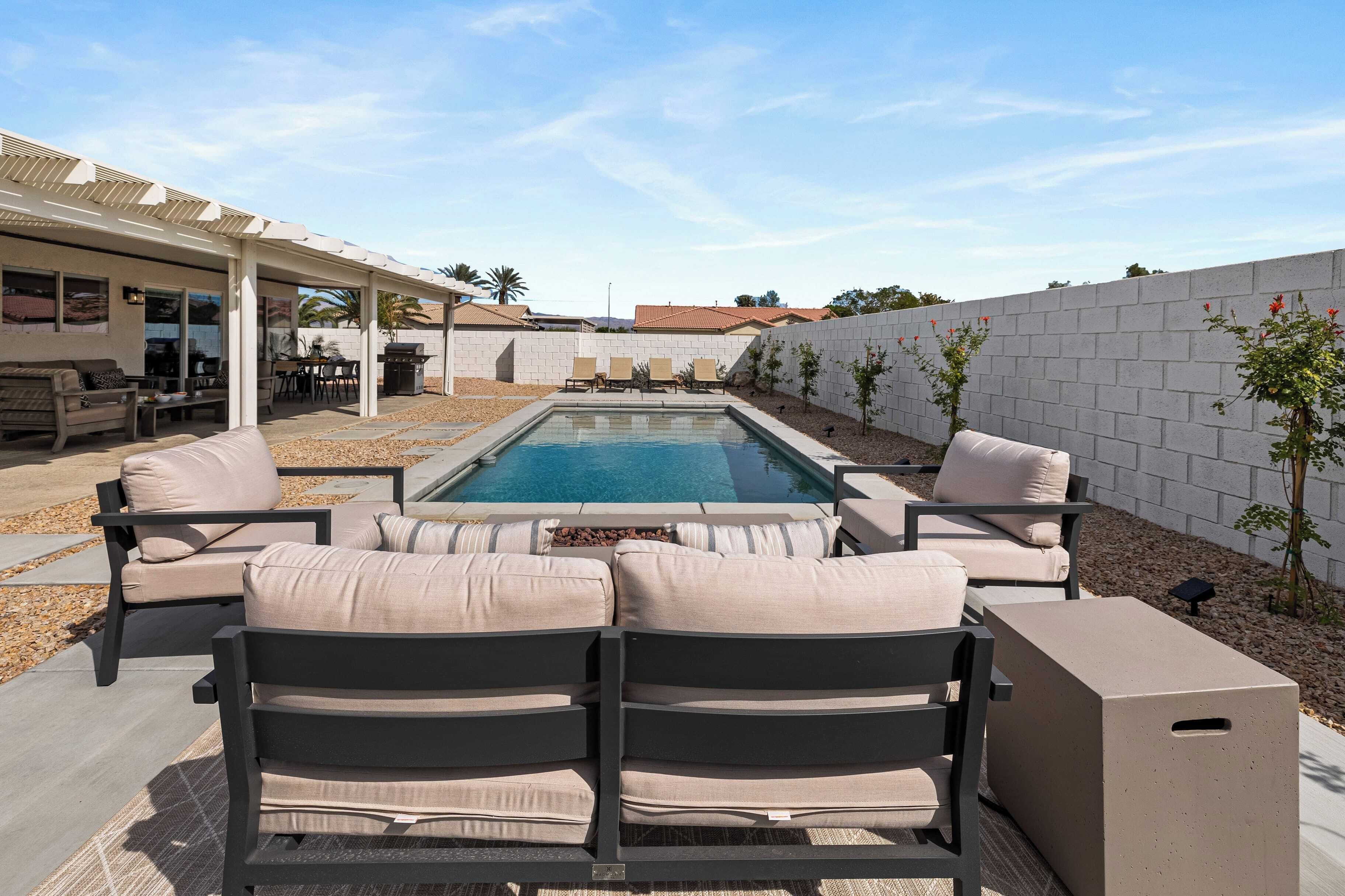 Ein Poolbereich mit Sitzgelegenheiten und einer überdachten Terrasse.