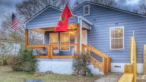 A house with a porch, a flag, and a wooden fence. - Newly Renovated, Charming Home Near Downtown! (Chattanooga)