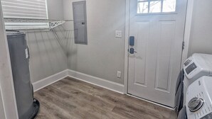 A laundry room with a door, a window, a vent, and a washing machine. - Newly Renovated, Charming Home Near Downtown! (Chattanooga)