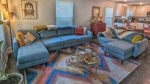 A living room with a sectional sofa, a coffee table, and a patterned rug. - Newly Renovated, Charming Home Near Downtown! (Chattanooga)