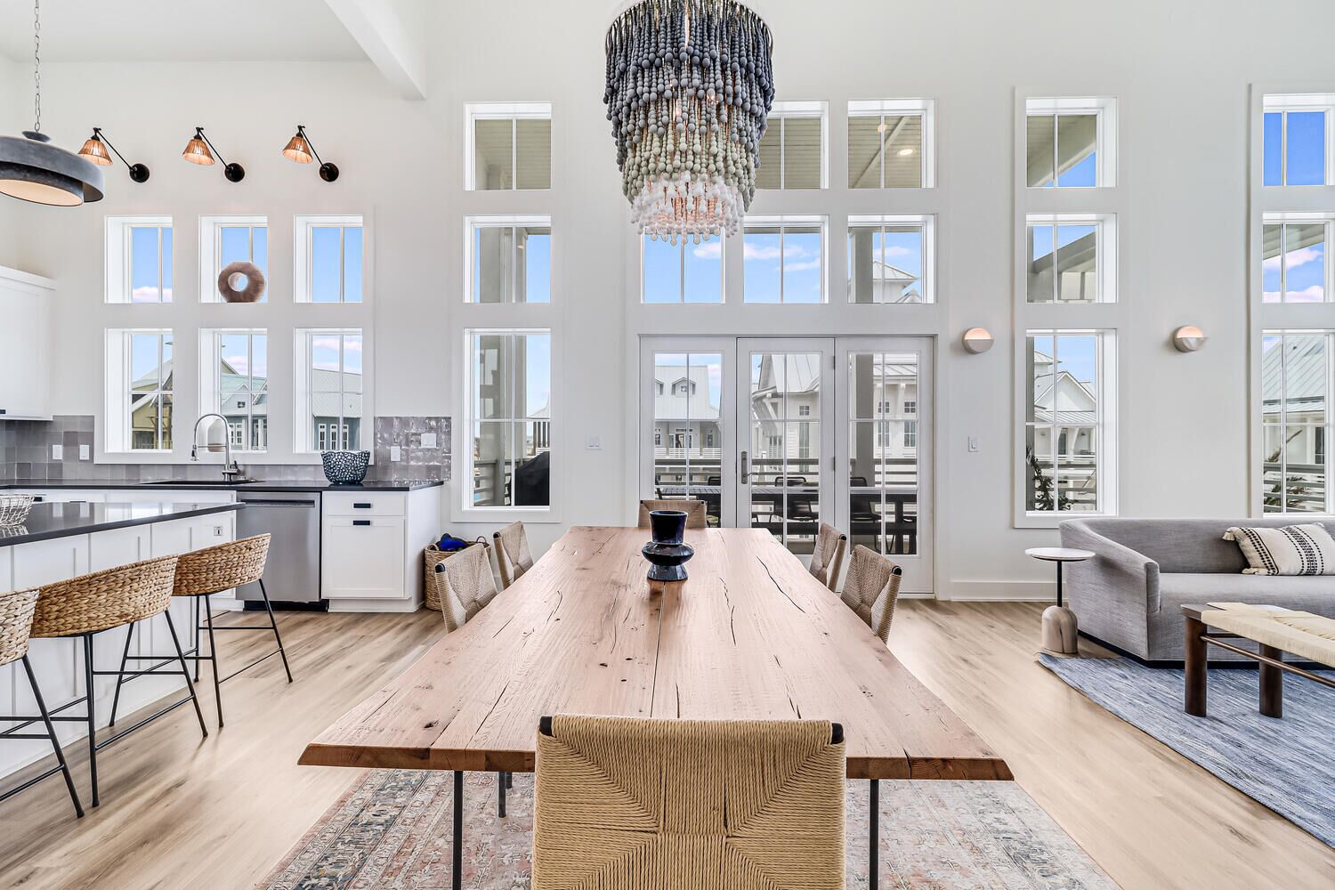 A spacious kitchen with a large island, a dining area with a wooden table, and a living area with a sofa and a TV.