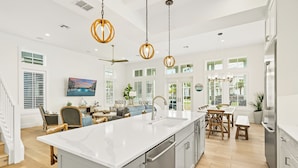 A spacious kitchen with a large island, stainless steel appliances, and pendant lighting. - Beach Blue 227 LAU (Port Aransas)
