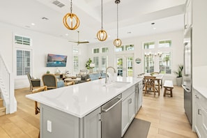 A spacious kitchen with a large island, stainless steel appliances, and pendant lighting. - Beach Blue 227 LAU (Port Aransas)