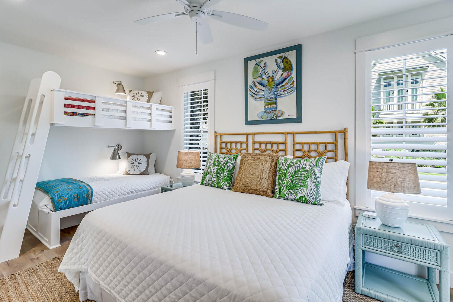 A bedroom with a large bed, a ceiling fan, a wall-mounted shelf with storage boxes, a window with blinds, and a painting above the bed.