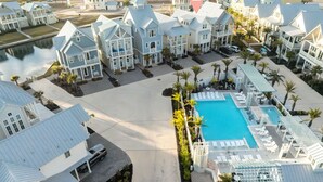 A resort with multiple two-story buildings, a central swimming pool, and a beach view. - Surf Camp 104 NEI (Port Aransas)