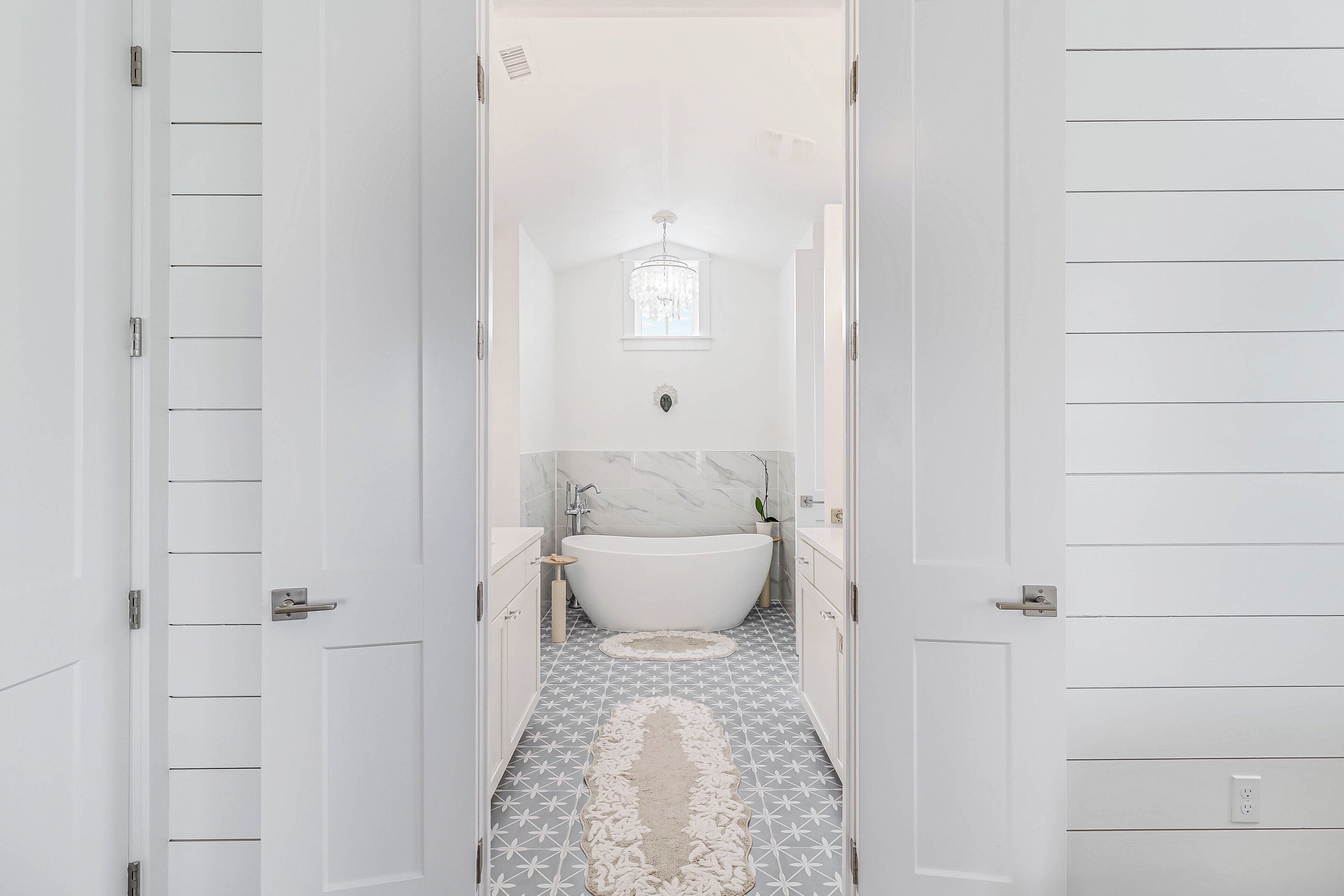 Une salle de bain avec une baignoire sur pieds, un lavabo en marbre et un carrelage décoratif.