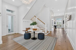 Ein modernes Interieur mit Treppe, einem runden Tisch mit zwei Stühlen und einem Blumentopf.