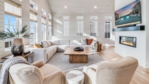 A spacious living room with a large sectional sofa, a wooden coffee table, and a fireplace. - One More Day 310 DAR (Port Aransas)