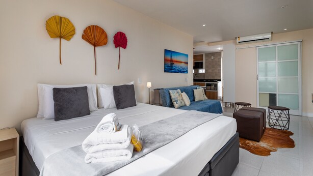 Una habitación de hotel moderna con una cama grande, un sofá y una zona de comedor.