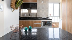 Una cocina moderna con encimera de granito, armarios de madera y salpicadero con azulejos estampados.
