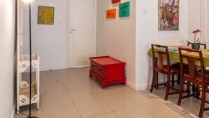 A dining area with a table set for four, a red crate, and a floor lamp. - 7 minutes from Ipanema beach | BT201 (Rio de Janeiro)