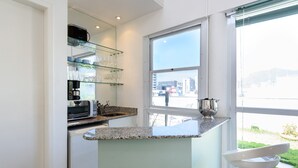 A modern kitchen with a granite countertop, a built-in microwave, and a coffee maker. - Penthouse in Ipanema | Christ View | MQC502 (Rio de Janeiro)