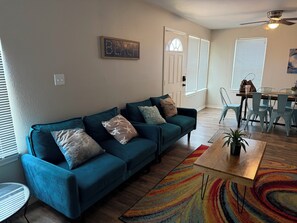 A living room with a teal sofa, a coffee table, and a colorful rug. - A SPRING / SUMMER / WINTER TEXAN FAV!!!! Full kitchen.
Sleeps 7! Free parking (Aransas Pass)